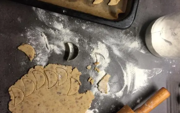Do prosáté mouky přidáme citrónovou kůru,cukr,mandlovou mouku,rozsekané hrozinky,tlučený hřebíček a skořici. Těsto spojíme žloutky a máslem a vypracujeme.Necháme v lednici odležet (třeba přes noc). Vyválíme 3 mm silný plát a vykrojíme půlměsíčky.
Pečeme dorůžova. Pak je ještě teplé na plechu potřeme citrónovou polevou,kterou si umícháme z prosátého moučkového cukru a citrónové šťávy. 

Poznámky:
V původním receptu bylo 140 g cukru,já použila 100g. Na spojení surovin,byly uvedeny jen 2 vejce,směs byla sypká,tak jsem přidala 125 g másla. V původním receptu,se udělalo těsto a hned se vyválelo...já dala na noc odležet,ať se chutě a vůně krásně propojí.