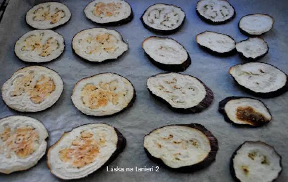 Ako prvé som dala variť šošovicu a zatiaľ som chystala baklažán.
 Umytý som nakrájala na plátky, posolila a nechala vypotiť. Potom som ich jemne poutierala servítkou, uložila na plech na papier na pečenie a dala piecť do vyhriatej rúry na 180°C asi 20 minút.