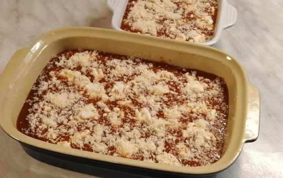 Trubičky zalijeme rajčatovou omáčkou (část omáčky si můžeme nechat na servírování), poklademe nastrouhanou mozzarellou a posypeme nastrouhaným sýrem parmezánového typu.