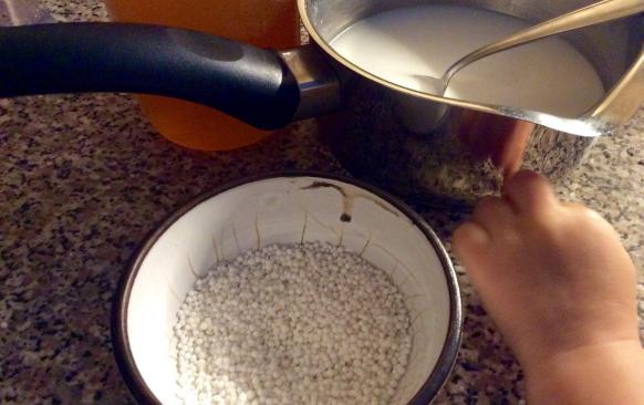 Kokosové "mléko" nalijte do hrnce, přidejte rýžový sirup a při středním výkonu plotýnky za občasného míchání uveďte do varu. Vsypte tapiokové perličky.