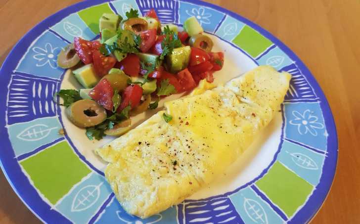 Vaječná omeleta, salát s rajčaty, avokádem a olivami